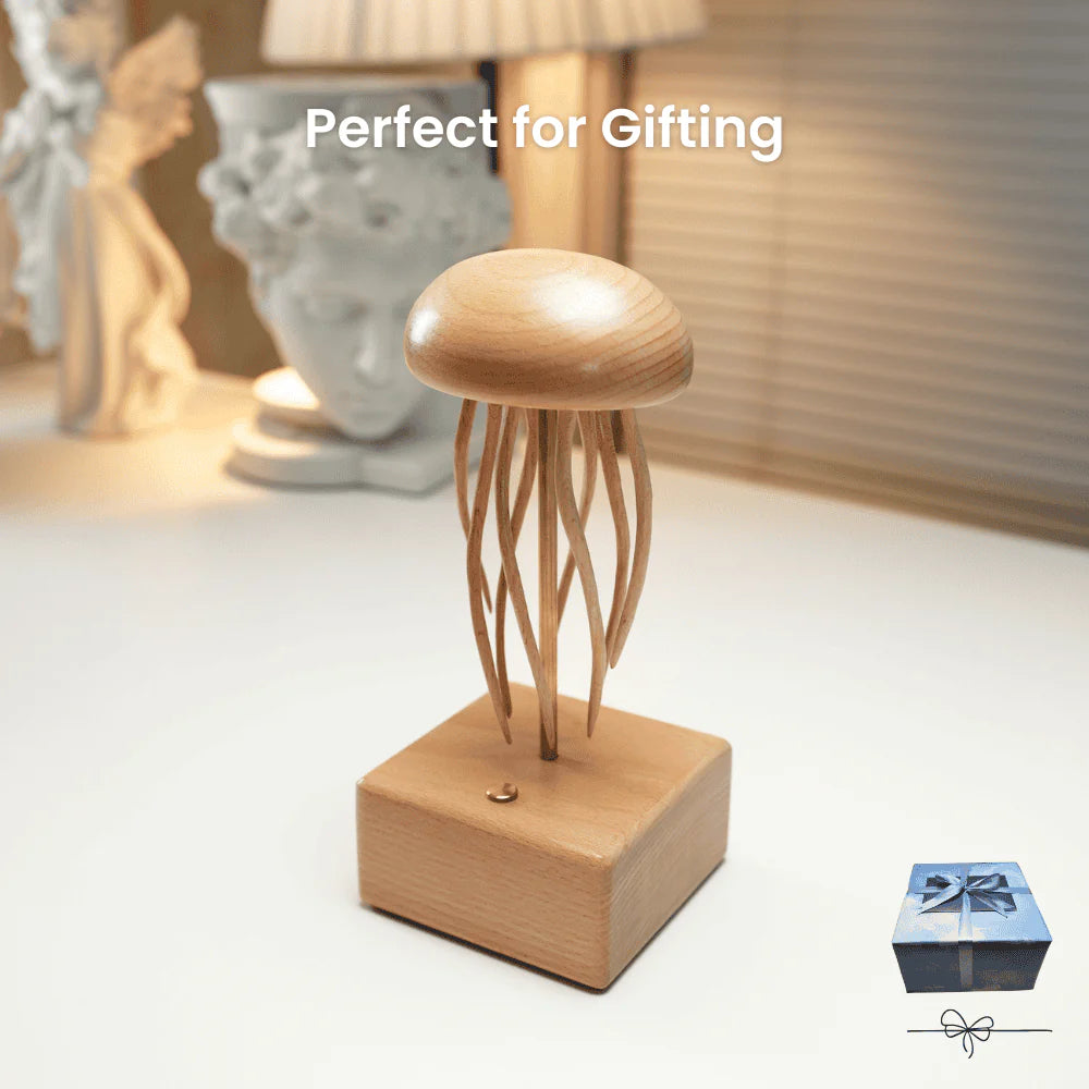 Wooden jellyfish-shaped lamp on a white surface with a gift box in the background.